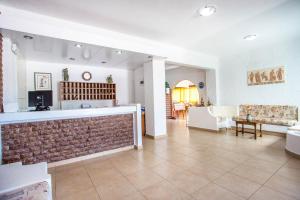 a living room with a brick wall and a couch at Muses Hotel in Faliraki