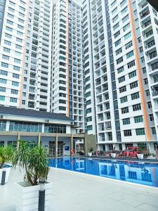 un gran complejo de apartamentos con piscina frente a edificios altos en Adelea Homestay MERU, en Ipoh