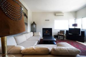 a living room with a white couch and a fireplace at Sea view Penthhouse in Souda