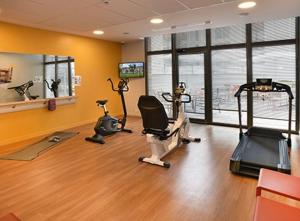 a gym with bikes and exercise equipment in a room at Domitys Les Raisins Bleus in Villiers-sur-Marne