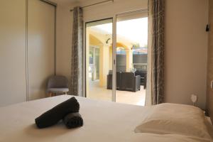 een slaapkamer met een bed en uitzicht op een patio bij Villa Marine en bord de mer... in Lumio +27 foto's