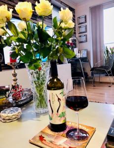 una botella de vino y una copa en una mesa en Beautiful apartment in SW London, en Sutton