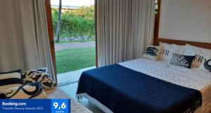 
a bedroom with a bed and a window at PRAIA DO FORTE - PISCINAS NATURAIS in Praia do Forte
