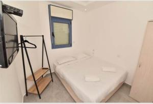 a white room with a bed and a window at רויאל פארק אילת in Eilat