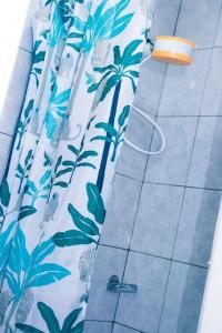 a shower curtain with palm trees on it in a bathroom at Maven Glow Elegant Studios in Kiambu