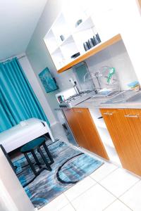a kitchen with a sink and a stool on a rug at Maven Glow Elegant Studios in Kiambu