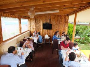 un grupo de personas sentadas en mesas en un restaurante en Villa d'Or Hotel, en Agva