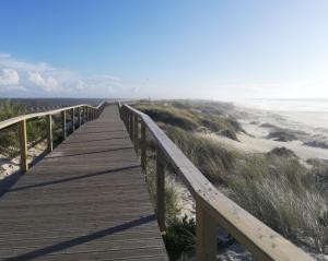 a wooden boardwalk leading to the beach at O VIOLAS - Art Coffee & Guesthouse in Praia de Mira