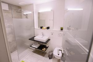biała łazienka z umywalką i toaletą w obiekcie Hotel Restaurant Lamm Rosswag w mieście Vaihingen an der Enz