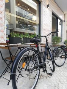 dwa rowery zaparkowane przed sklepem w obiekcie O VIOLAS - Art Coffee & Guesthouse w mieście Praia de Mira