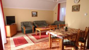 a living room with a couch and a table at Mandula Wellness Apartmanház in Harkány