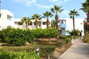 een resort met palmbomen en een gebouw bij Muses Hotel in Faliraki