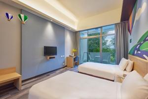 pokój hotelowy z dwoma łóżkami i telewizorem w obiekcie Naruwan Inn w mieście Taidong