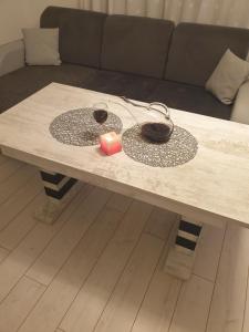 a coffee table with two glasses and a candle on it at Cosy Charming Apartment in Blagoevgrad
