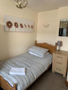 a bedroom with a bed with two towels on it at The Cottage At The Retreat in Leek
