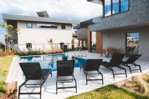 a patio with chairs next to a swimming pool at Cabo Villas in Arapya