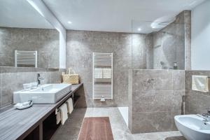 ein Bad mit einem Waschbecken und einem Spiegel in der Unterkunft Oberwirt Weisses Kreuz in Steinegg