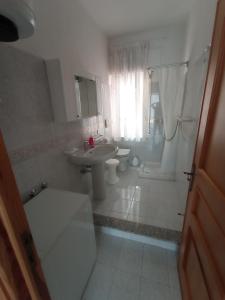Carpe Diem في سينيسكولا: حمام أبيض مع حوض ومرحاض