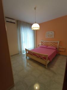 a bedroom with a large bed with a pink blanket at Carpe Diem in Siniscola