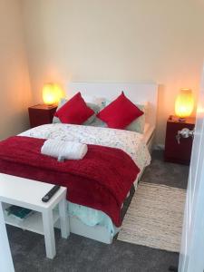 um quarto com uma cama grande e almofadas vermelhas em Luxurious & Spacious 5 Bedroom Property em Belvedere
