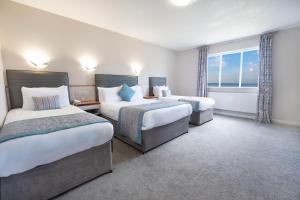 a hotel room with two beds and a window at Livermead Cliff Hotel in Torquay