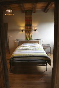 a bedroom with a bed with a striped blanket at Grande maison de caractère en pierres -superbe vue in Saint-Cirgues +36 photos