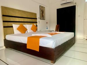 a bedroom with a large bed with orange and white pillows at 360 Beach Residence in Negombo
