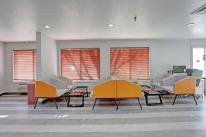una sala de espera con sillas, mesas y ventanas en Quality Inn Pierre-Fort Pierre en Pierre