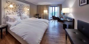a large white bed in a hotel room at Parkhotel Pforzheim in Pforzheim +42 photos