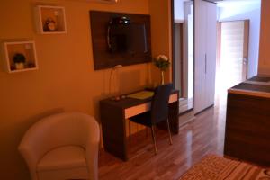 a room with a desk with chairs and a television at Kalelarga 4 You Apartments in Zadar
