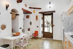 cocina con paredes blancas, mesa y sillas en Casita Tahona en Teguise