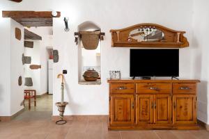 una TV su un mobile in legno in una stanza di Casita Tahona a Teguise