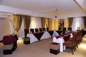 a banquet room with tables and chairs and curtains at Anta Boga Hotel in Bloemfontein