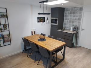 cocina y comedor con mesa de madera y sillas en Family Inn Kaatsheuvel, en Kaatsheuvel