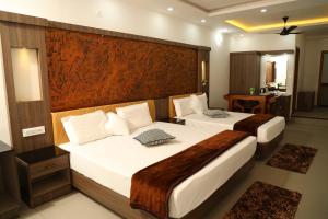 een hotelkamer met 2 bedden en een groot hoofdeinde bij Green Valley Residency in Kattappana