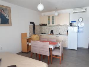 kuchnia ze stołem i krzesłami oraz białą lodówką w obiekcie Apartments Kipson w Nin