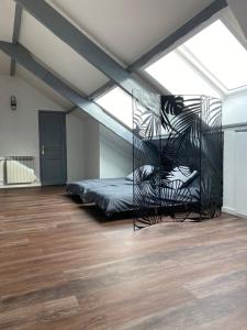 a bedroom with a bed in a room with wood floors at Villa Manoca in Boisemont