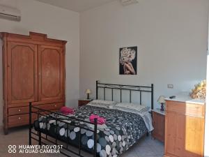 um quarto com uma cama e um armário de madeira em L'abete em Guspini
