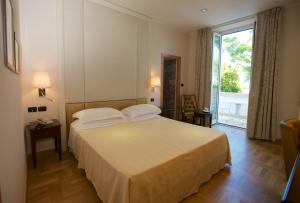a bedroom with a large bed and a large window at Grand Hotel Mediterranee in Alassio