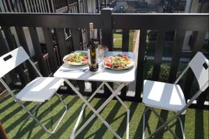 una mesa con dos platos de comida y una botella de vino en Apt With Balcony At 350 M From The Beach en Cabourg