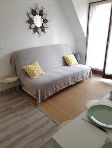 sala de estar con sofá y almohadas amarillas en Apt With Balcony At 350 M From The Beach en Cabourg