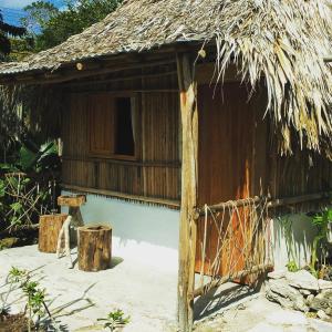 Cabaña pequeña con techo de paja y puerta en Cabañas Alma Verde, en Bacalar