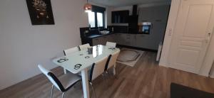 a dining room table with chairs and a kitchen at Gites Ostheim in Ostheim