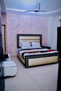 - une chambre avec un lit orné d'un mur fleuri dans l'établissement Hotel Tulip Inn, à Lahore