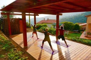 um grupo de pessoas fazendo yoga em um deck em Villa Shanti Yoga & Meditation em Marciana