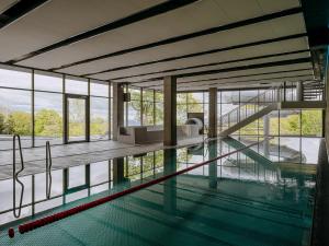 an indoor swimming pool with a view of a building at VacationClub – Górna Resorts Apartament 2.08 in Szklarska Poręba