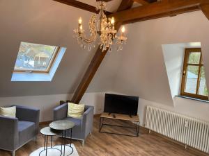 a living room with a chandelier and a tv at FEWO Königsberg Weingut C A Haussmann in Traben-Trarbach