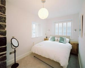 a bedroom with a white bed and white walls at Cross Foxes - Bar Grill Rooms in Dolgellau