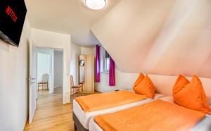 - une chambre dotée d'un lit avec des draps orange dans l'établissement Apartment Lannach, à Lannach