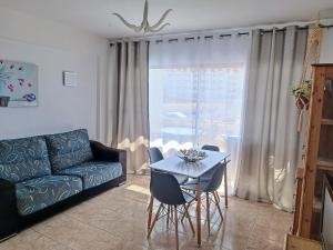 プエルト・デ・サンティアゴにあるOcean Viewのリビングルーム(ソファ、テーブル、椅子付)
